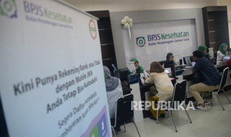 Petugas Badan Penyelenggara Jaminan Sosial (BPJS) Kesehatan melayani warga di kantor BPJS Kesehatan Cabang Jakarta Selatan, Senin (2/9).