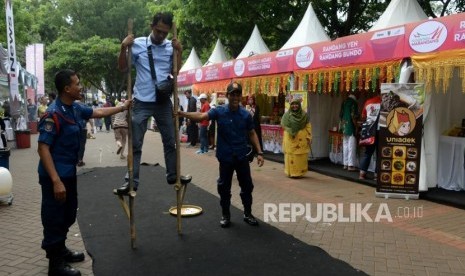 Pengunjung memcoba permainan tradisional pada acara Festival Nusantara Marandang 2018 di Kawasan Gelora Bung Karno,Senayan, Jakarta, Ahad (2/12).