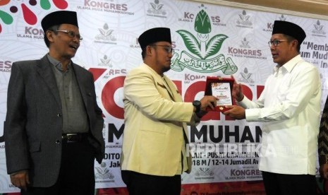 Ketua PP Muhammadiyah Yunahar Ilyas bersama Ketua Umum PP Pemuda Muhammadiyah Dahnil Anzar Simanjuntak dan Menteri Agama Lukman Hakim Saifuddin (dari kiri) usai memberikan cinderamata pada pembukaan Kongres Ulama Muda Muhammadiyah di Aula Gedung Dakwah Muhammadiyah, Menteng, Jakarta, Selasa (30/1).