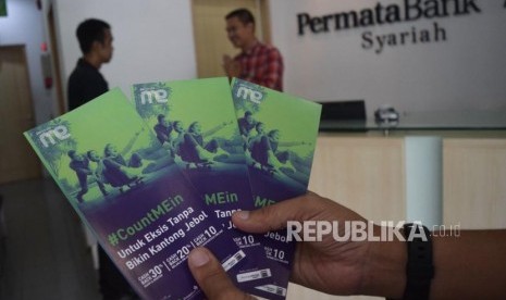 Karyawan melayani transaksi nasabah di Permata Bank Syariah Jakarta,Jumat (9/11). Perbankan syariah membutuhkan lebih banyak insentif untuk meningkatkan daya saing. Kepala Unit Usaha Syariah Bank Permata, Herwin Bustaman menyampaikan daya saing industri dapat ditingkatkan dengan sejumlah insentif, termasuk pajak.