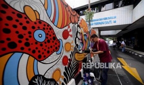 Seniman mural Indonesia mengambar mural dalam acara kongres kebudayaan Indonesia di Kementerian Pendidikan dan Kebudyaan  Indonesia, Jakarta, Kamis (6/12).