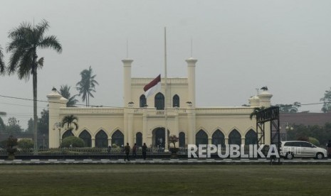 Warga melintas di dekat Istana Siak Sri Indrapura yang mengibarkan bendera setengah tiang di Kabupaten Siak, Riau, Selasa (10/9).(Republika/Putra M. Akbar)