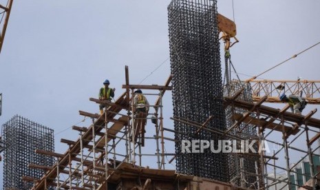 Pekerja beraktivitas dipembangunan gedung bertingakat di Jakarta, Ahad (30/12).