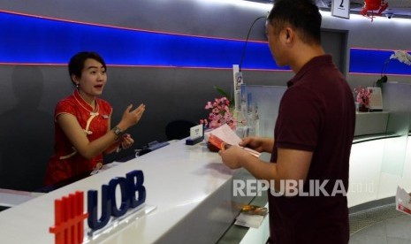 Nasabah melakukan transaksi saat festival Li Chun, satu hari sebelum perayaan imlek di Bank UOB Indonesia, Jakarta, Senin (4/2).