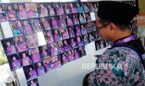 Sejumlah calon jamaah haji melihat foto yang dipajang di Asrama Haji Pondok Gede, Jakarta, Kamis (26/7).