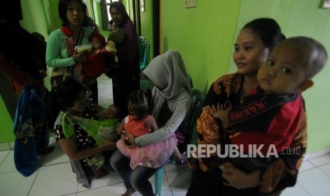 Sejumlah warga mengantre sebelum melakukan imunisasi difteri untuk anaknya di Puskemas Cimanggis, Depok, Jawa Barat, Rabu (6/12).