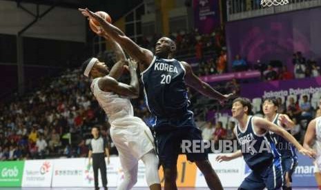 Pemain basket Korea Ricardo Ratliffe menghalangi lemparan bola pemain Indonesia Jamarr Andre Johnson pada babak laga Grup A Asian Games 2018 di Hall Basket Senayan, Jakarta, Selasa (14/8).