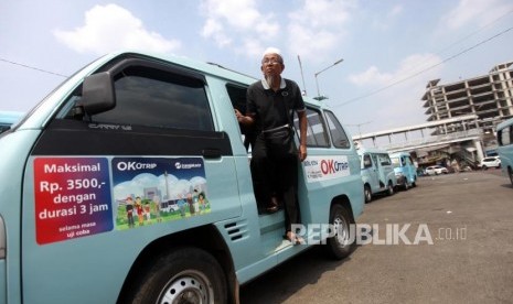 Penumpang turun dari angkutan umum dengan menggunakan kartu Ok-Otrip di Terminal Kampung Melayu, Jakarta, Senin (9/7).