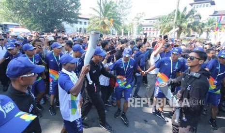 Altlet Timnas sepak bola era 2000-an Alexander Pulalo membawa obor Asian Games di Jalan Diponegoro, Kota Bandung, Sabtu (11/8).