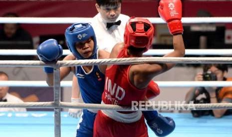 Petinju Indonesia Huswatun Hasanah (biru) saat berlaga dengan petinju petinju India Pavita dalam pertandingan perempat final cabang Tinju Kelas ringan putri 57-60 Kg Asian Games 2018 di Hall Jakarta International Expo, Kemayoran, Jakarta, Selasa (28/8).