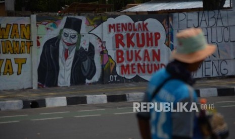 Warga melintas di area mural Tolak RUU RKUHP di Rawamangun, Jakarta Timur, Senin (30/9/2019).