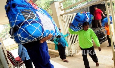 Sejumlah porter membawa koper calon jamaah haji di Asrama Haji Pondok Gede, Jakarta, Selasa (24/7).