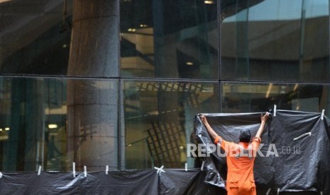 Selasar Ambruk. Petugas menutup kaca depan lobby usai ambruknya selasar di Tower II BEI, Jakarta, Senin (15/1).