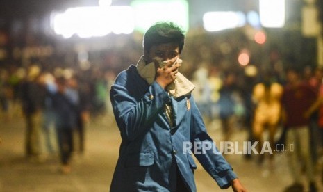 Sejumlah mahasiswa menutup hidung usai ditembakan gas air mata di depan Gedung DPR, Jakarta, Selasa (24/9).