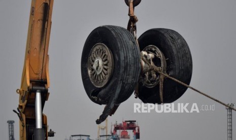 Petugas gabungan mengevakuasi roda pesawat Lion Air JT 610 dari kapal LCU KRI Banda Aceh saat tiba Posko Terpadu Pelabuhan Tanjung Priok, Jakarta, Sabtu (3/11).