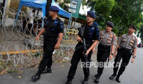 Anggota kepolisian berkeliling melakukan pengamanan di depan Gedung KPU, Jakarta, Ahad (19/5).