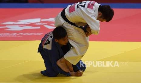 Atlet Judo Indonesia Muhammad Alfiansyah Lubis  (biru ) saat melawan Atlet Judo Kazakthan Yeldos Smetov  di  Babak Eliminasi 16 besar Putra 60 kg cabang olaharaga Judo Asian Games, di JCC, Jakarta,Rabu (29/8).