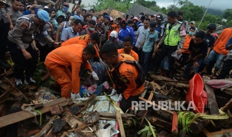 Sejumlah petugas gabungan mengevakuasi jenazah korban tsunami yang tertimbun reruntuhan bangunan di Desa Way Muli, Kalianda, Lampung Selatan, Senin (24/12).