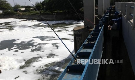 Warga memancing ikan di Kali Banjir Kanal Timur, Jakarta, Selasa (23/1).