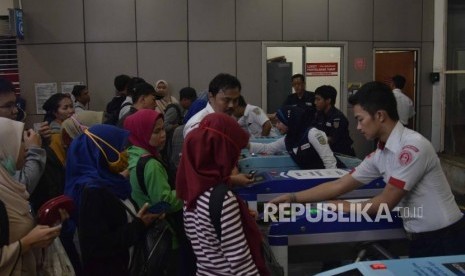 Petugas KRL membantu penumpang saat akan menggunakan tiket elektronik di Statsiun Manggarai, Jakarta, Senin (23/7).