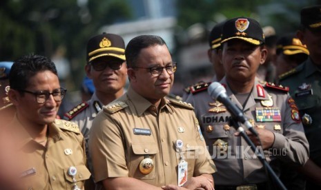 Gubernur DKI Jakarta Anies Baswedan (tengah) bersama Wakil Gubernur DKI Jakarta Sandiaga Salahudin Uno (kiri) dan Kapolda Metro Jaya Inspektur Jenderal Polisi Idham Azis (kanan) memberikan keterangan kepada media seusai apel Mantap Praja Jaya 2017 di Polda Metro Jaya, Jakarta, Selasa (31/10).