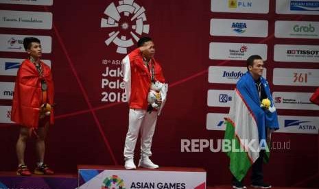 Lifter Indonesia  Eko Yuli  Irawan melakukan penghormatan kepada bendera sang merah putih dalam upacara penyerahan medali di cabang angkat besi putra nomor 62 Kg Asian Games 2018 di Hall A Kemayoran, Jakarta, selasa (21/8).