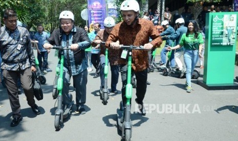 Didampingi Executive Director Grab Indonesia Ongki Kurniawan (kanan) Menteri PPN/Kepala Bappenas Bambang Brodjonegoro (kedua kiri) mencoba moda transportasi e-scooter GrabWheels pada acara ITB CEO NET 2019, di Aula Barat Kampus ITB, Bandung, Selasa (1/10).