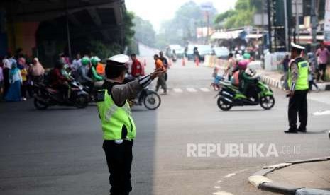 Petugas polisi mengatur lalu lintas saat pawai obor Asian Games 2018 di Kawasan Pasar Rebo, Jakarta, Rabu (15/8).