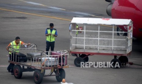 Petugas masukan barang milik penumpang ke bagasi pesawat di Bandara Internasional Soekarno-Hatta, Tanggerang,Banten, Kamis (7/2).