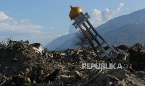 Relawan melintas di sekitar Masjid Daarul Mutakin yang terletak di perumnas Balaroa, Palu, Sulawesi Tengah, Senin (8/10).