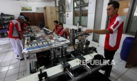 Seorang guru menunjukan kepada siswa Sekolah Menengah Kejuruan (SMK) Program Logic Controller (PLC) saat praktik kejuruan di SMK Negeri 1, Jakarta, Senin (1/10).