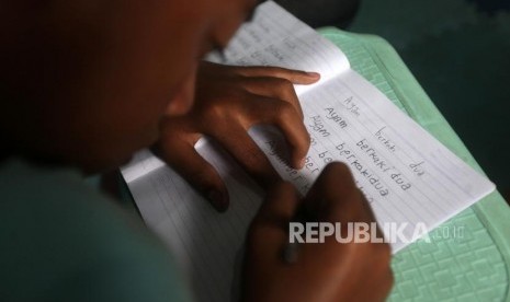 Seorang anak menulis saat kegiatan belajar bersama di Rumah Belajar Merah Putih, Kawasan Cilincing, Jakarta, Senin (22/10).