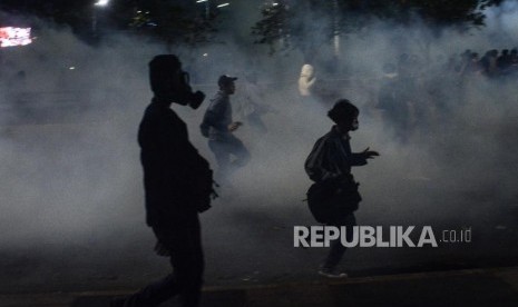 Massa Aksi Mahasiswa Indonesia berlari menghindari gas air mata saat aksi di depan kawasan Jalan Tol Dalam Kota Gatoto Soebroto, Jakarta, Selasa (24/9/2019).