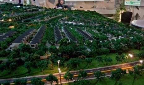 Penjaga stan berada di dekat sebuah miniatur kawasan perumahan pada pameran properti Real Estate Indonesia (REI), di Semarang, Jawa Tengah, Jumat (16/11/2018).