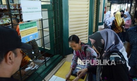 Sejumlah orang tua murid menandatangani daftar nama anaknya yang diterima di SMAN 5 Bandung, melalui jalur PPDB, di Jalan Belitung, Kota Bandung, Kamis (12/7).