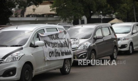 Kendaraan taksi online terparkir saat melakukan aksi unjuk rasa di Kawasan Monumen Nasional (Monas), Jakarta, Senin (29/1).