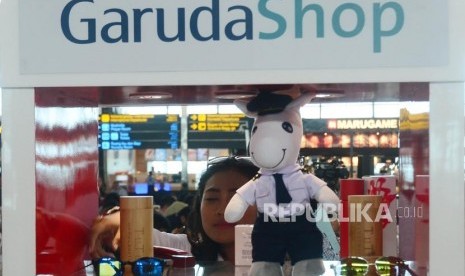 Seorang petugas GarudaShop sedang merapihkan merchandise eksklusif Garuda Indonesia disela acara peluncuran Garuda Shop JD.ID di Terminal 3 Bandara Soekarno Hatta, Cengkareng, Selasa (13/2).