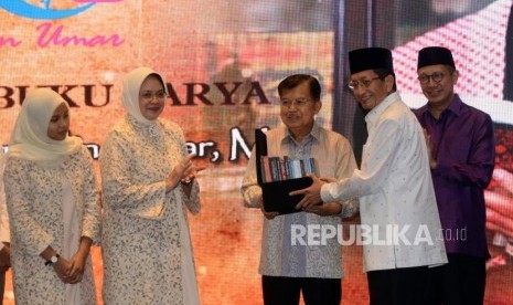 Imam Besar Masjid Istiqlal Nasaruddin Umar memberikan buku karanganya kepada Wakil Presiden Jusuf Kalla pada acara tasyakuran 60 tahun dan peluncuran buku di Jakarta, Ahad (23/6).