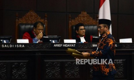 Komisioner KPU Hasyim Asyari saat akan memberikan barang bukti sampul surat suara sah dari pihak termohon pada sidang lanjutan Perselisihan Hasil Pemilihan Umum (PHPU) Pemilihan Presiden (Pilpres) 2019 di Gedung Mahkamah Konstitusi, Jakarta, Kamis (20/6).