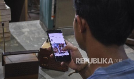 Pekerja melihat katalog produk di media sosial menggunakan gawai (ilustrasi)