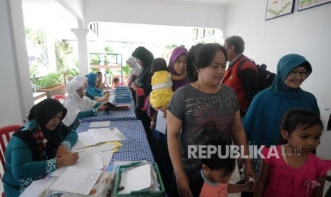 Imunisasi Massal Difteri. Sejumlah warga mengantre untuk melakukan imunisasi Difteri kepada anaknya di Posyandu Mawar, Pancoran Mas, Kota Depok, Jawa Barat, Senin (11/12).