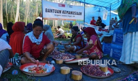 Ibu-ibu dan bapak-bapak pengungsi bergotong royong memotong-motong daging sapi dan memasak di dapur umum Posko Kemanusiaan ACT, di desa Lompio, Kabupaten Sirenja, Donggala Sulawesi Tengah, Ahad (14/10).