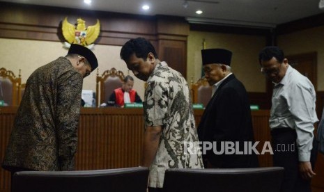 Menteri Agama Lukman Hakim Saifuddin (kiri) dan Mantan Ketua Umum PPP Romahurmuziy (kedua kiri) bersiap menjalani sidang untuk menjadi saksi di Pengadilan Tipikor, Jakarta, Rabu (26/9).