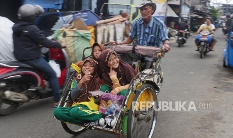 Tiga orang pelajar nampak tersenyum saat berada di dalam becak.