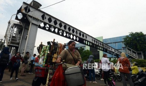 JPO Pasar Minggu. Warga melintas di dekat Jembatan Penyeberangan Orang (JPO) yang rusak di Pasar Minggu, Jakarta, Selasa (5/3).