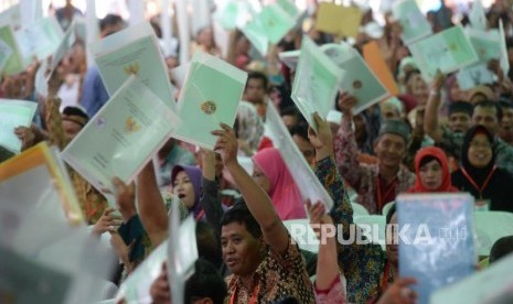 Penyerahan Sertipikat Tanah. Warga menunjukan sertipikat tanah usai penyerahanSertipikat Tanah Untuk Rakyat oleh Presiden Joko Widodo di Samarinda, Kalimantan Timur, Kamis (25/10).