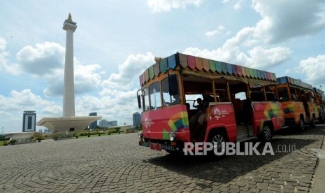 Pengunjung menaiki mobil di kawasan Monumen Nasional (Monas), Jakarta. Unit Pengelola Kawasan Monumen Nasional (Monas) menghentikan sementara layanan mobil wisata kawasan cagar budaya itu selama Pembatasan Sosial Berskala Besar (PSBB) transisi.