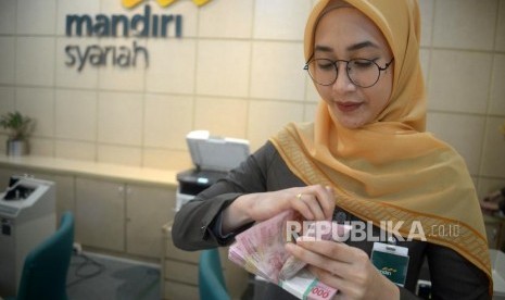 Pembiayaan BSM. Petugas melayani transaksi nasabah di kantor layanan Bank Mandiri Syariah, Jakarta, Senin (12/3).