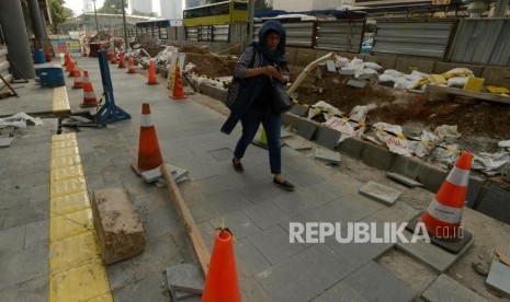 Warga berjalan di samping proyek penataan trotoar /Ilustrasi 