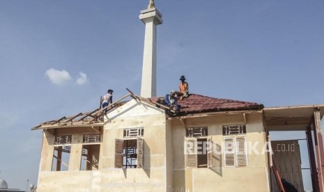 Persiapan Lebaran Betawi Monas. Pekerja menyelesaikan pembuatan replika rumah adat betawi di kawasan Monumen Nasional, Jakarta Pusat, Kamis (18/7).